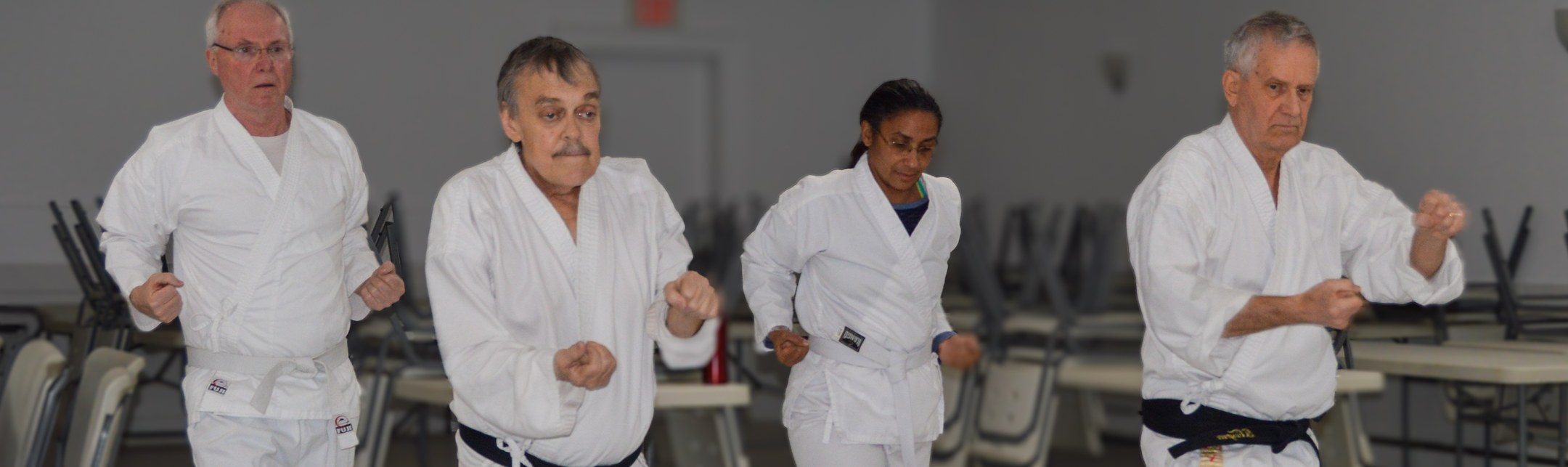 Four adults in white karate gi training together at the Bracebridge Legion.